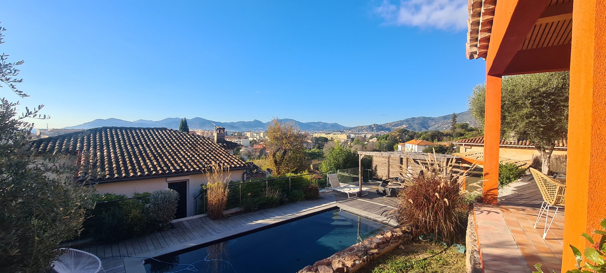 La piscine privée le long du deck en bois, avec vue sur les toits jusqu’aux collines de l’Estérel