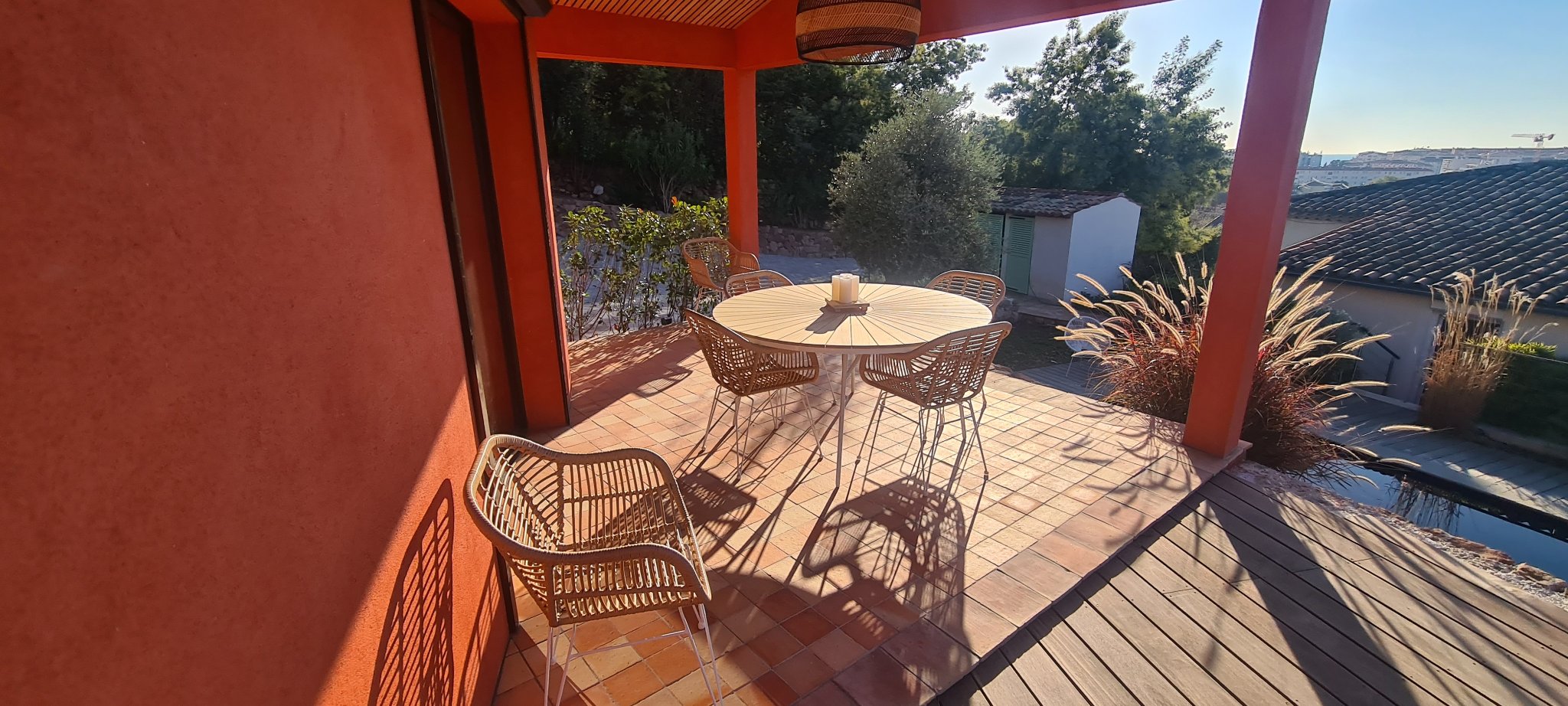 The covered terrace of the house, with a dining table under the beams